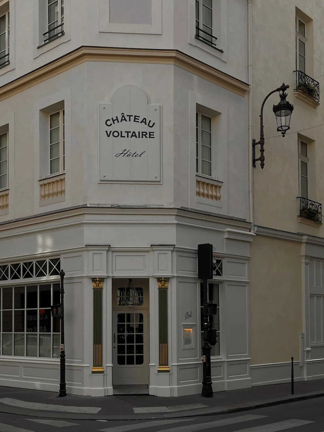 White concrete building named Chateau Voltaire Hotel